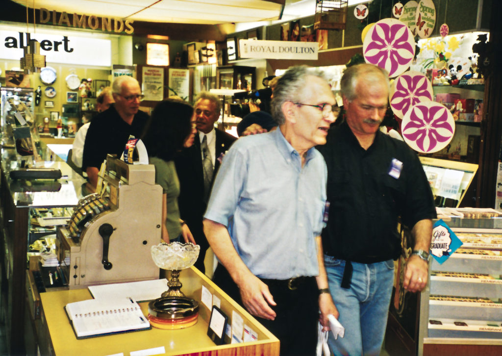 June 1999 Photo inside the former 'Albert Jewellers' at 718 Queen E, with the late Albert Edelstein (forefront at left) speaking with the late Jack Layton (June 23rd, 1999) (Photo from the Edelstein Family)