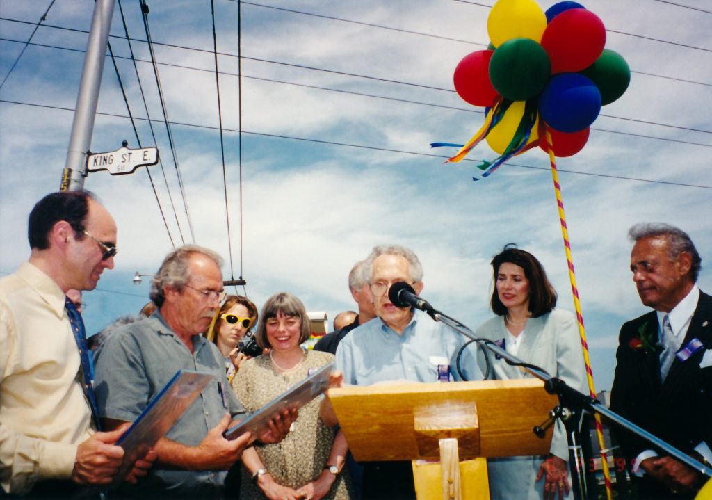 This June 1999 photo shows Albert Edelstein speaking at the launch of new public wayfinding art in the Queen-Broadview Village BIA with local officials (now Riverside BIA) (Photo from the Edelstein Family)